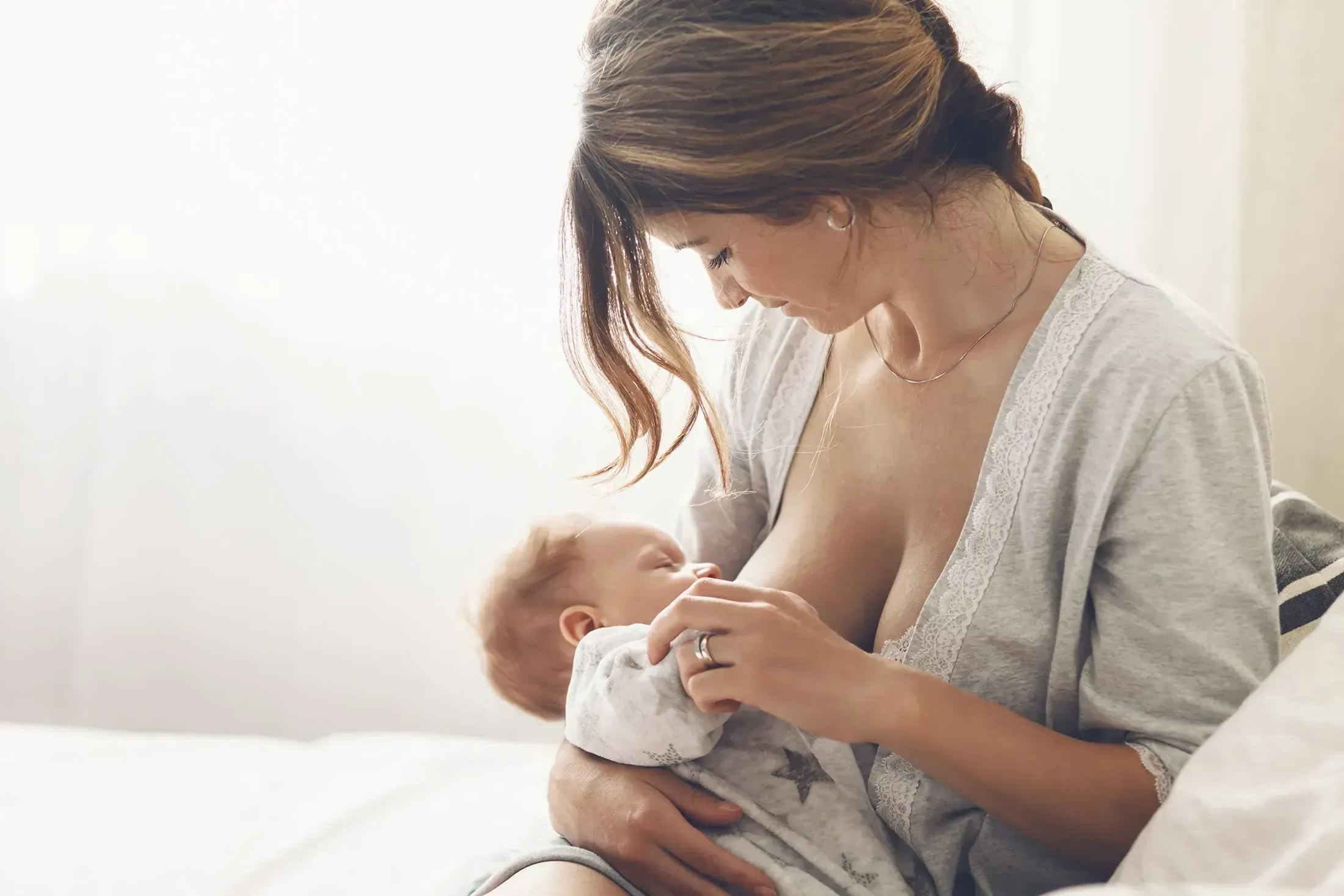 A mother breastfeeding her newborn at home